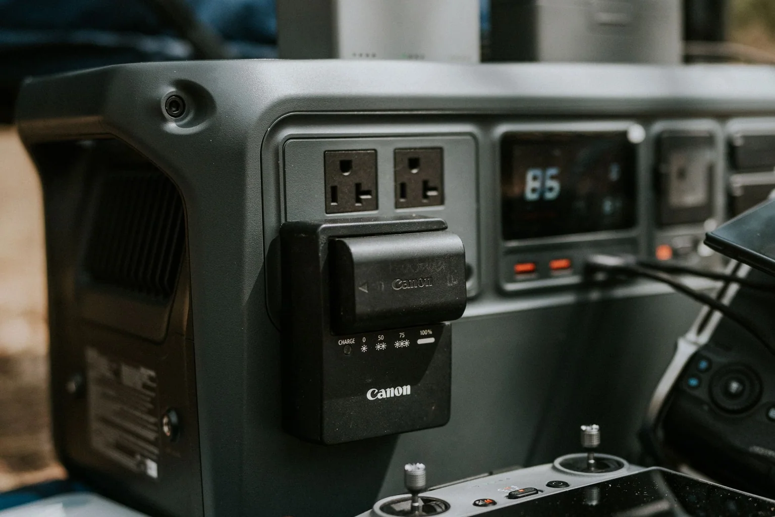 Portable power station charging camera and drone batteries in an outdoor gear setup